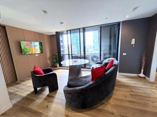 a living room with two chairs and a table at Aura on Flinders Serviced Apartments in Melbourne