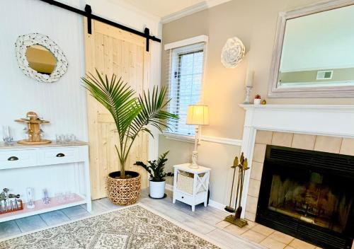 a living room with a fireplace and a plant at Luxury Villa- 3 mins to Mohegan- Fully Stocked with Fireplace- Jacuzzi, Saltwater Pools, Sauna in Norwich