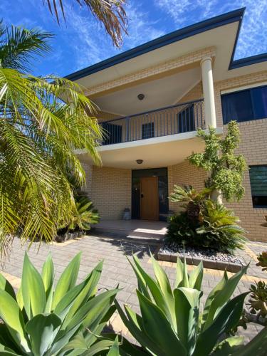 a building with palm trees in front of it at Sunny Ocean View Retreat in Perth