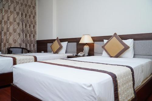 um par de camas num quarto de hotel em Khách sạn Hữu Nghị em Vinh