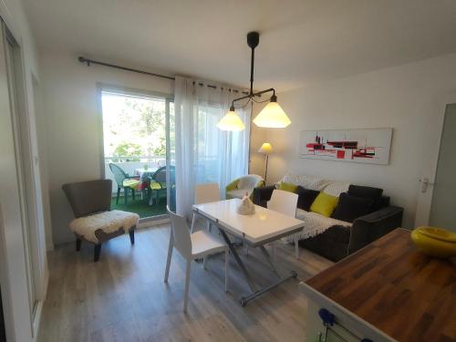 un salon avec une table et un canapé dans l'établissement Appartement Confortable à Saint Jean de Monts - Plage, Balcon, Parking, Wifi Gratuit - FR-1-323-454, à Saint-Jean-de-Monts