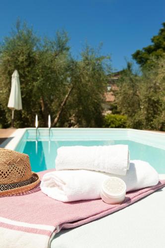 a straw hat and towels on a table next to a pool at Villa Fiorenzani in Radicondoli