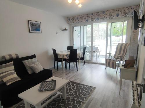 un salon avec un canapé et une table dans l'établissement Appartement cosy à 220m de la plage avec terrasse privée, proche centre et forêt - St Jean de Monts - FR-1-323-463, à Saint-Jean-de-Monts