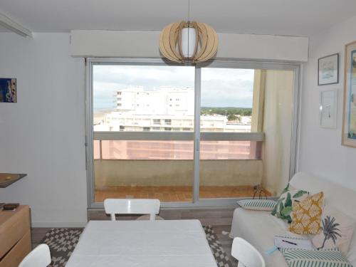 un salon avec un canapé et une grande fenêtre dans l'établissement Appartement cosy à 50m de la plage pour 4 pers. avec balcon à Saint Hilaire de Riez - FR-1-323-448, à Saint-Hilaire-de-Riez