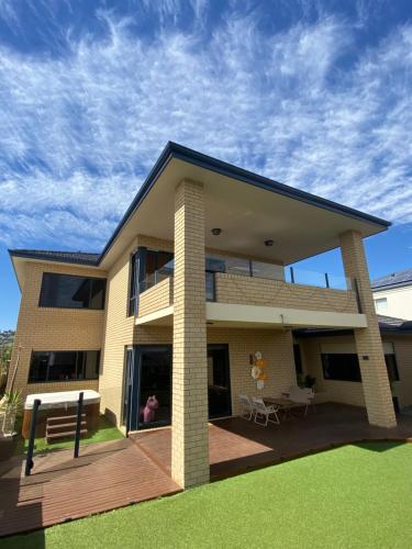 uma casa com um deque de madeira em frente em Sunny Ocean View Retreat em Perth