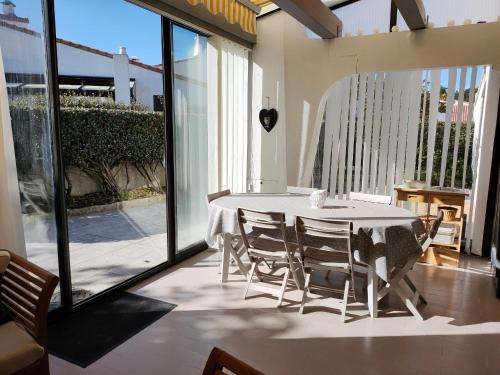 une salle à manger avec une table et des chaises blanches dans l'établissement Maison charmante, moderne, proche plage, jardin privé, parking, Saint Jean de Monts - FR-1-323-433, à Saint-Jean-de-Monts