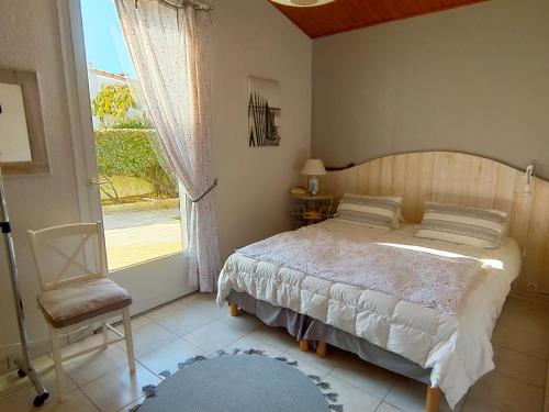 une chambre avec un lit, une chaise et une fenêtre dans l'établissement Maison charmante, moderne, proche plage, jardin privé, parking, Saint Jean de Monts - FR-1-323-433, à Saint-Jean-de-Monts