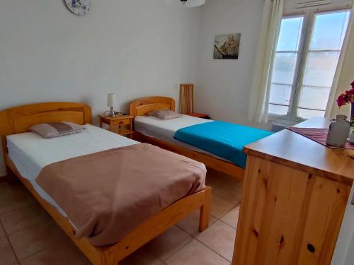 une chambre avec deux lits et une table et une fenêtre dans l'établissement Maison avec 2 chambres, piscine privée et jardin clos à Saint-Jean-de-Monts - FR-1-323-439, à Saint-Jean-de-Monts