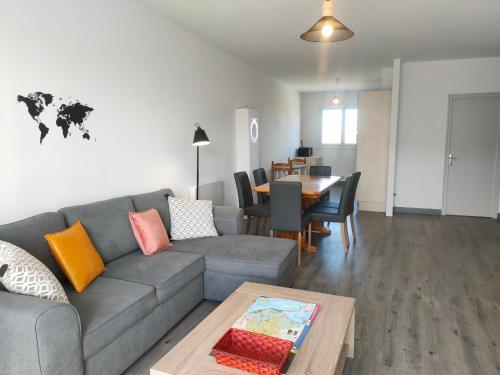 un salon avec un canapé gris et une table dans l'établissement Appartement rénové 4 pers, 200m plage, proche commerces, balcon, parking, animaux admis - FR-1-323-443, à Saint-Hilaire-de-Riez