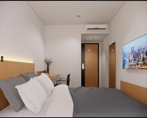 1 dormitorio con 1 cama y una pintura en la pared en Check Inn Permata Hijau en Semarang