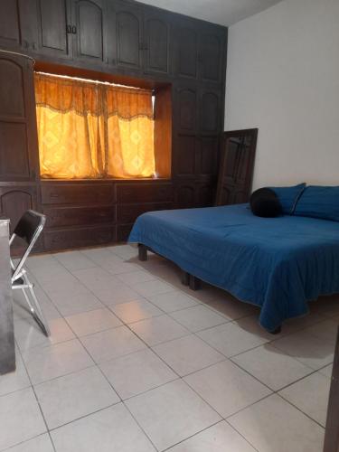 sypialnia z niebieskim łóżkiem i oknem w obiekcie Casa Mata w mieście Cedral