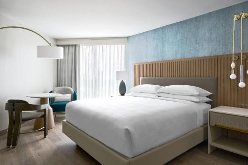 a bedroom with a large white bed and a table at VEA Newport Beach, a Marriott Resort & Spa in Newport Beach
