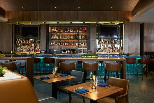 a restaurant with wooden tables and chairs and a bar at VEA Newport Beach, a Marriott Resort & Spa in Newport Beach