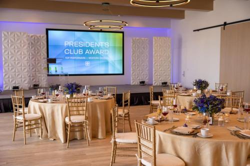 a conference room with tables and chairs and a projection screen at VEA Newport Beach, a Marriott Resort & Spa in Newport Beach