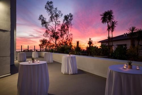 two tables on a balcony with a sunset at VEA Newport Beach, a Marriott Resort & Spa in Newport Beach