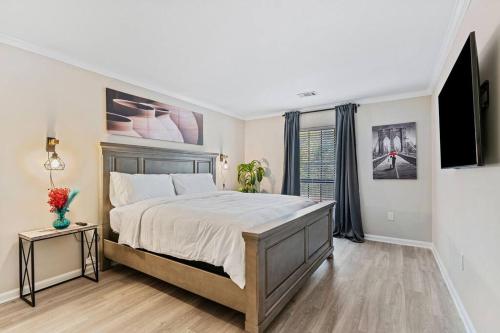 a bedroom with a large bed and a flat screen tv at G - Atlanta Luxury 1bdr 1bath ensuite shared Condo in prime location in Atlanta