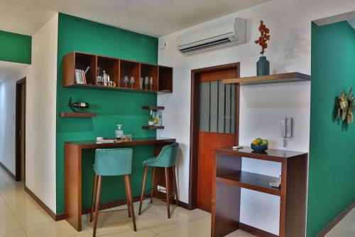Habitación con una pared verde, escritorio y sillas. en EMERALD@On320 en Colombo