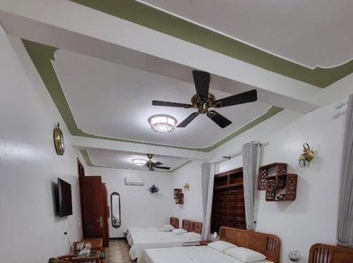 a room with several beds and a ceiling fan at Thac Tien Village Ba Vi in Ba Vì