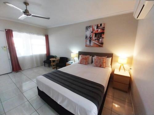 a bedroom with a large bed in a room at Tropic Coast Motel in Mackay