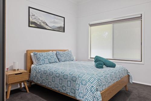 a bedroom with a bed with a teddy bear on it at Snow-Berri in Berridale