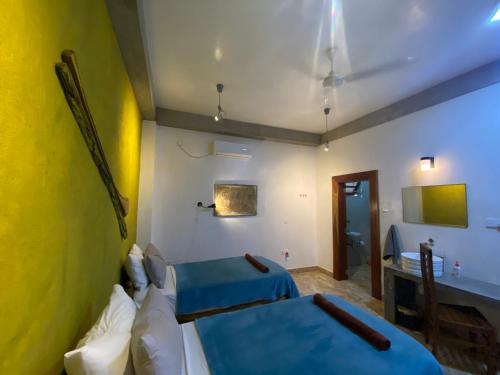 a room with two beds and a desk in it at Virage Beach House @ Morava Court in Hikkaduwa