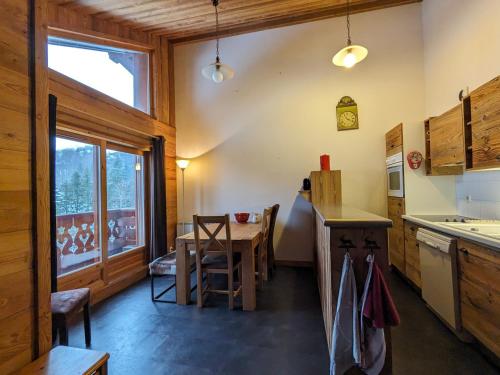 une cuisine avec une table et une salle à manger dans l'établissement Appartement cosy au pied des pistes avec balcon et parking couvert - FR-1-459-225, à La Clusaz