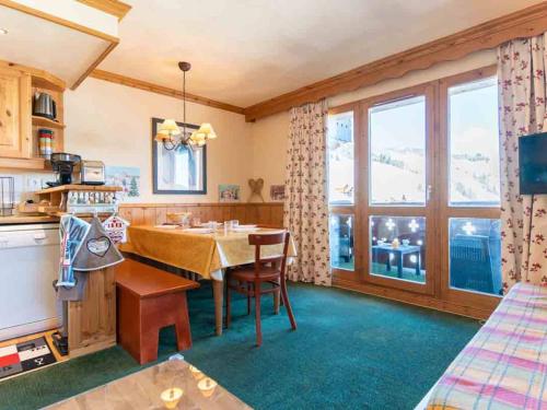 une cuisine avec une table et une grande fenêtre dans l'établissement Duplex 6 pers, Hameau de la Forêt, 3 chambres, balcons, ski-in/ski-out - FR-1-291-1006, à Valmorel