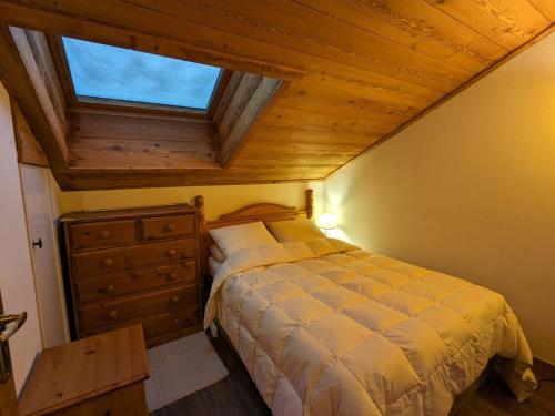 une chambre avec un lit avec un plafond en bois dans l'établissement Appartement cosy au pied des pistes avec balcon et parking couvert - FR-1-459-225, à La Clusaz