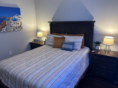 a bedroom with a bed with a striped bedspread and two lamps at On The Go Stays in Dallas