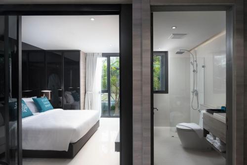 1 dormitorio con 1 cama y baño con ducha en Cross Vibe Pattaya Seaphere - formerly X2 Vibe Pattaya Seaphere, en Na Jomtien