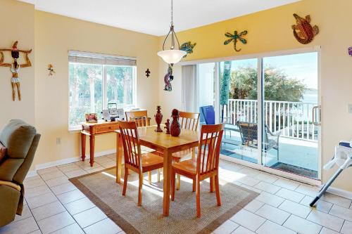 a dining room with a table and chairs and a balcony at South Harbour 2A in Pensacola Beach