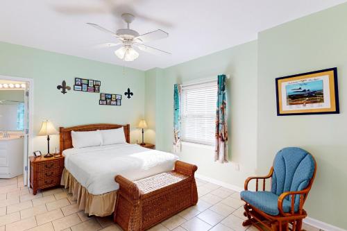 un dormitorio con una cama y una silla en South Harbour 2A, en Pensacola Beach