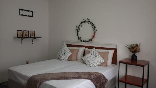 a bedroom with a bed with white sheets and a mirror at The garden house in Boksburg
