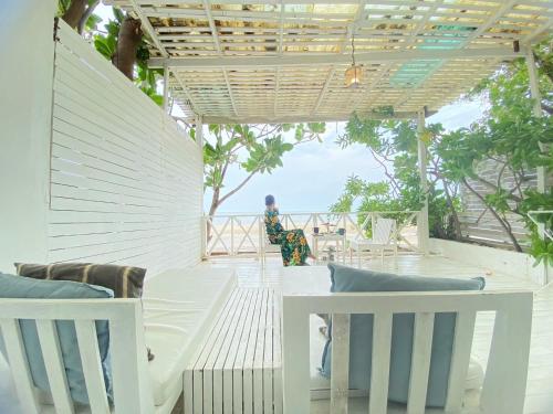 a woman sitting on the porch of a house at Green Gallery Beach Boutique Hotel in Hua Hin
