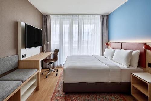 a hotel room with a bed and a desk and a television at Residence Inn by Marriott Munich Central in Munich