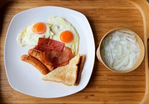 a plate of breakfast food with eggs and toast at SUNZI BOUTIQUE HOSTEL : ซันซิ บูทีค โฮสเทล in Betong
