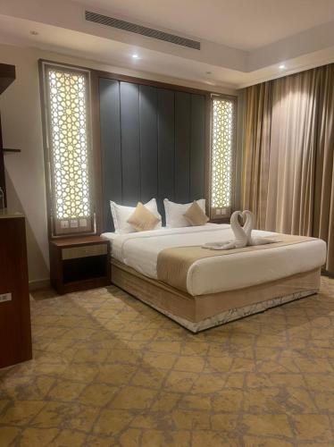 a bedroom with a large bed and two windows at درة العروس للوحدات السكنية المفروشة in Jeddah