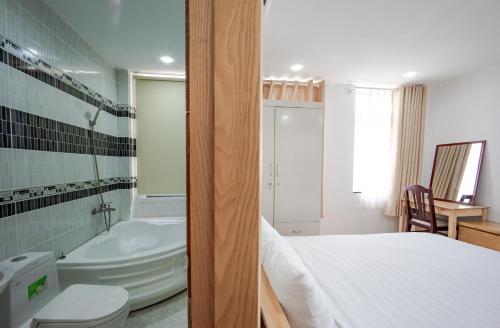 Un baño con una cama, una bañera y un lavabo. en INDO Serviced Apartment, en Ho Chi Minh