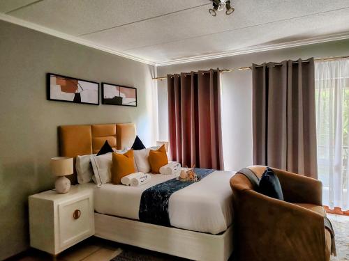 um quarto de hotel com uma cama e uma cadeira em Tevin Nest em Sandton