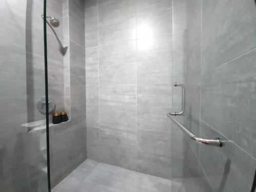 een badkamer met een douche en een glazen deur bij Kuching City Centre Smart Home Luxury Resort Condo in Kuching