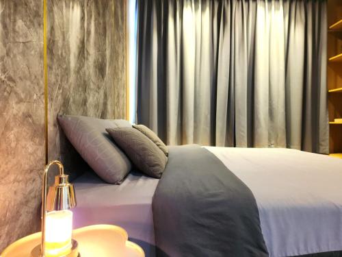 een slaapkamer met een bed met 2 kussens erop bij Kuching City Centre Smart Home Luxury Resort Condo in Kuching