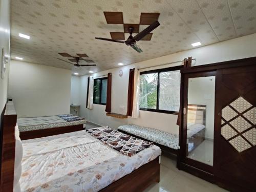 1 dormitorio con 2 camas y ventilador de techo en DR BHOIR FARM & RESORT, en Kalyan