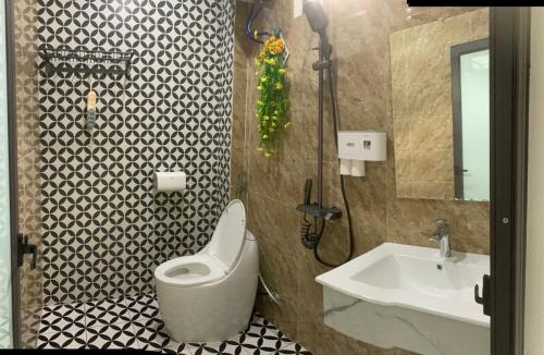 uma casa de banho com um WC branco e um lavatório. em Rustic Homestay - Phòng nghỉ giá rẻ em Hai Phong