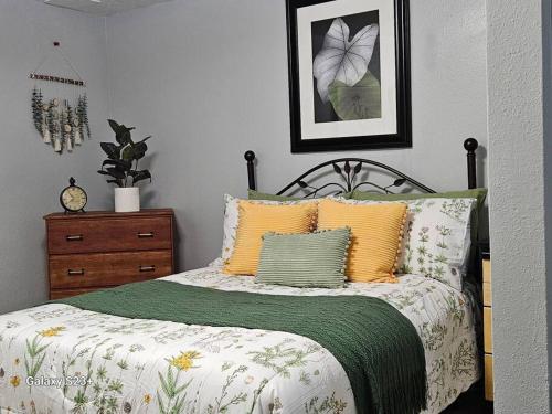 una camera da letto con un letto con cuscini gialli e verdi di Under the Dome a Pocatello