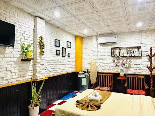 Homestay Tí Nị في Tây Ninh: غرفة مع طاولة وتلفزيون على الحائط