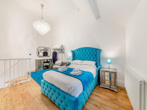 un letto blu in una camera bianca con testiera blu di Buttercup Cottage - Uk45969 a Yarm