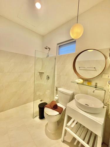 a bathroom with a toilet and a sink and a mirror at Green Gallery Beach Boutique Hotel in Hua Hin