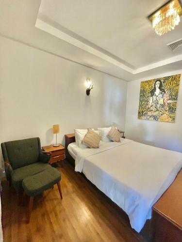 a bedroom with a large white bed and a chair at Green Gallery Beach Boutique Hotel in Hua Hin