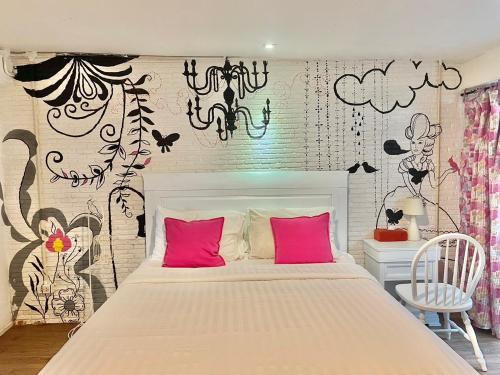a bedroom with a large white bed with pink pillows at Green Gallery Beach Boutique Hotel in Hua Hin