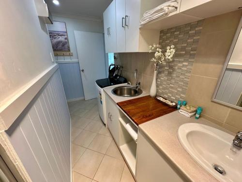 a small kitchen with a sink and a sink at Driftwood - Bunbury in Bunbury